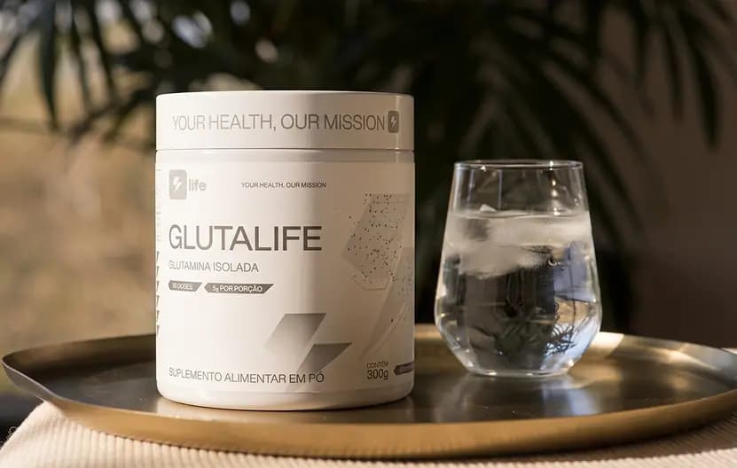 Pote de Glutalife ao lado de um copo de água, sobre uma bandeja dourada